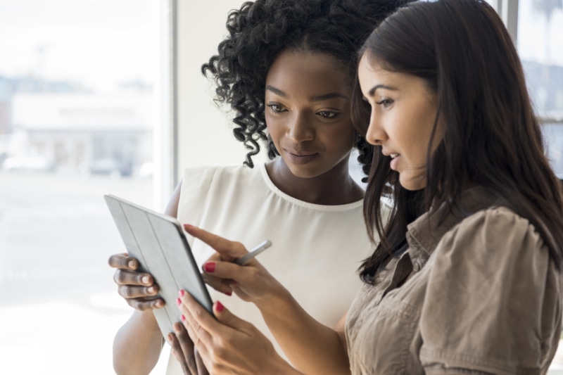 two women looking at tablet